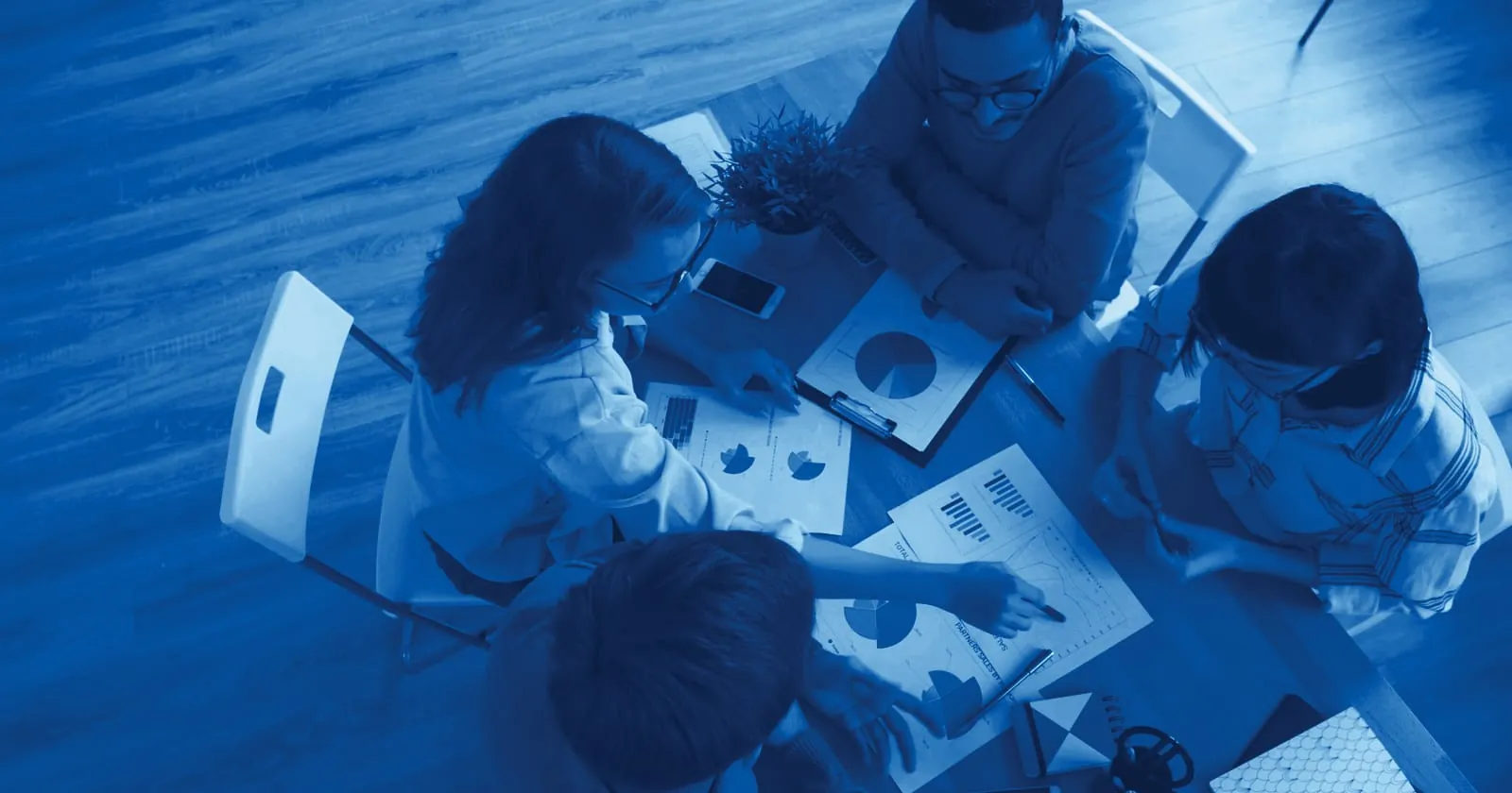 A team reviewing research charts around a table