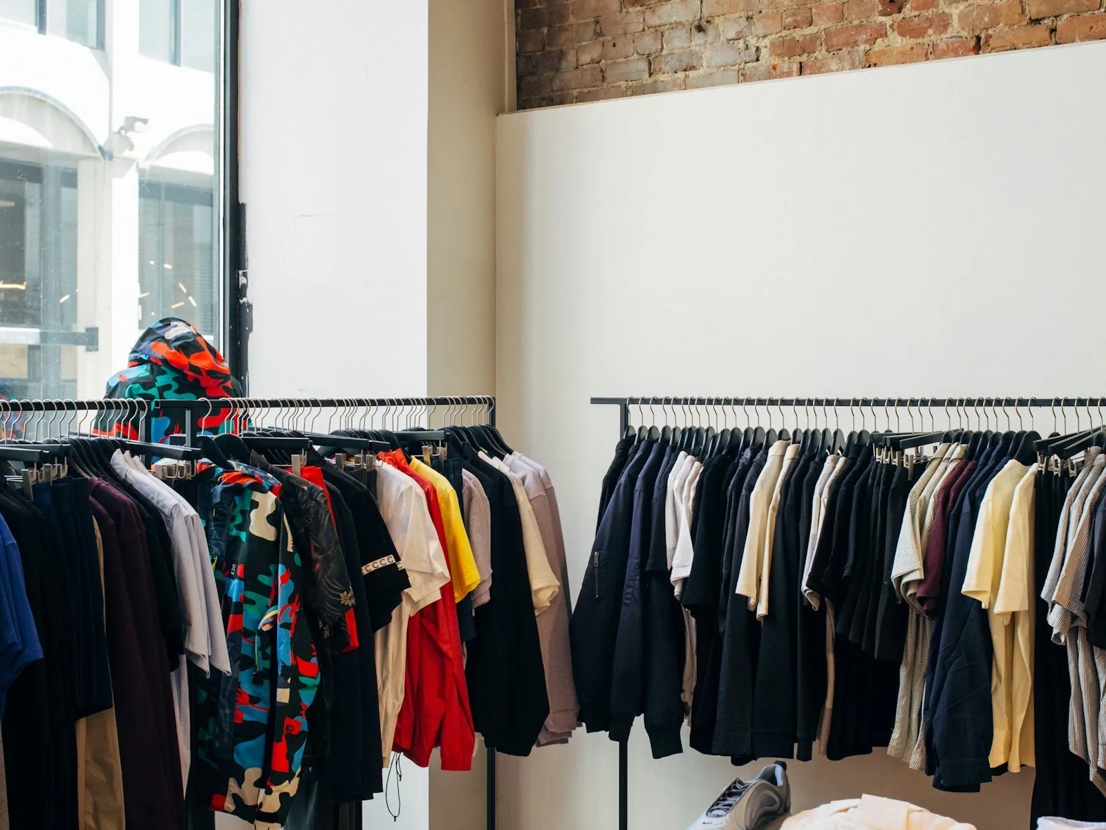 Rails of shirts, jackets and T-shirts in a bright clothing store